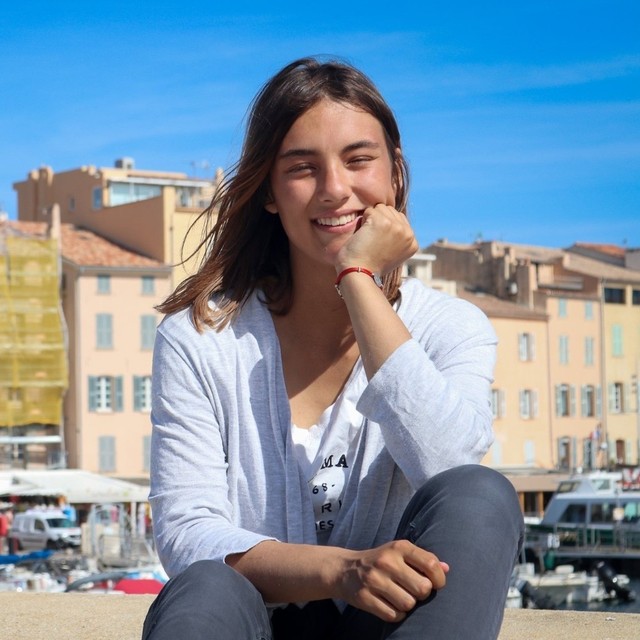 Marit Pompe, illustratrice, devant un port méditerranéen ensoleillé